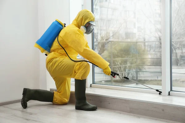 Trabajador Control Plagas Traje Protector Rociando Pesticida Cerca Ventana Interiores —  Fotos de Stock