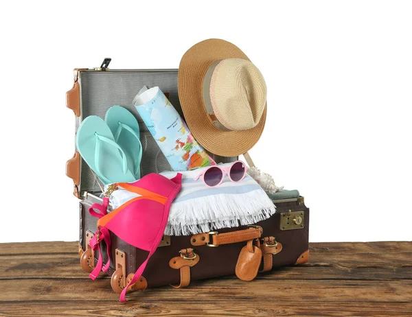 装有不同海滩物品的开放式老式手提箱 以白色为背景 装在木制桌子上度过暑假 — 图库照片