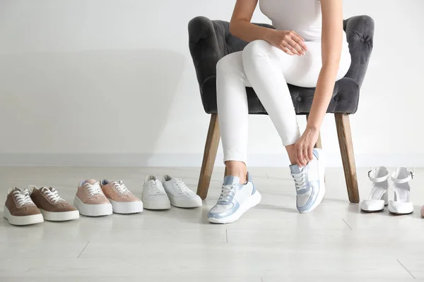 Mujer Joven Eligiendo Zapatos Mientras Está Sentado Sillón Primer Plano — Foto de Stock