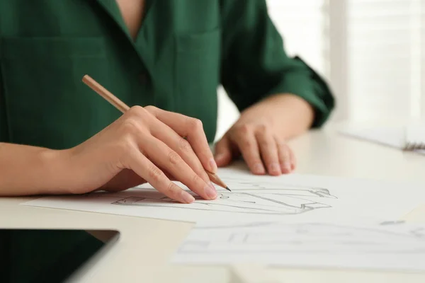 白いテーブルに紙の上に鉛筆で服を描く女性 クローズアップ — ストック写真