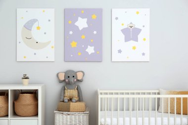 Bebek odasının içinde beşik ve duvarında sevimli posterler var.