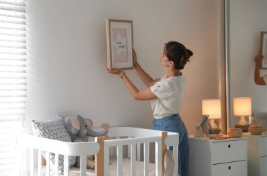 Bebek odasının duvarına asılı bir dekoratör resmi. İç tasarım