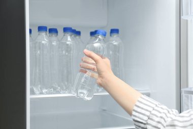 Buzdolabından su alan kadın, yakın plan.