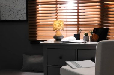 Pencerenin yanında rahat işyeri olan şık bir oda.