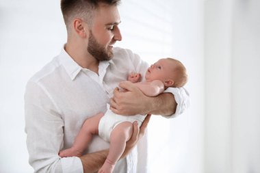 Baba ve yeni doğmuş oğlu aydınlık arka planda.