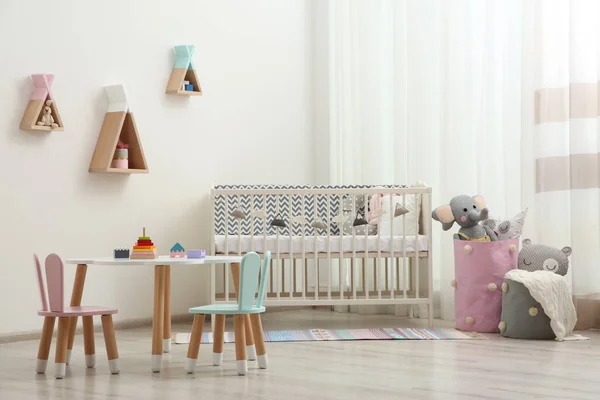 Niedliche Babyzimmereinrichtung Mit Kinderbett Und Kleinem Tisch — Stockfoto