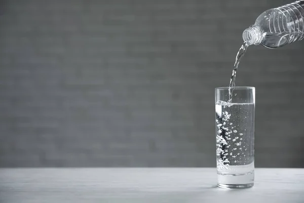 Wlewanie Wody Butelki Szklanki Stół Niewyraźne Tło Miejsce Tekst — Zdjęcie stockowe