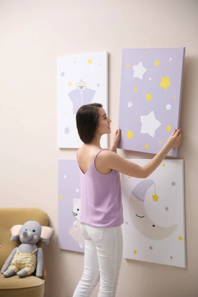 装潢师把画挂在粉红的墙上 儿童房室内设计 — 图库照片