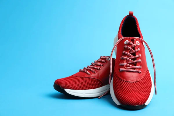 Stijlvolle Rode Sneakers Lichtblauwe Achtergrond Ruimte Voor Tekst — Stockfoto