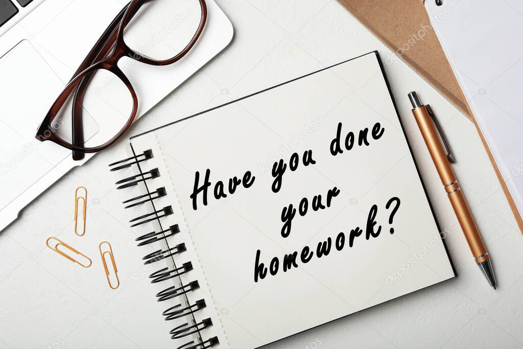 Stylish notebook with phrase HAVE YOU DONE YOUR HOMEWORK? on table, flat lay 