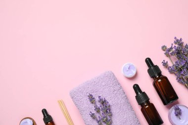 Kozmetik ürünleri ve pembe arka planda lavanta çiçekleri. Metin için boşluk