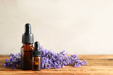 Ahşap masada gerekli yağ ve lavanta çiçekleri. Metin için boşluk