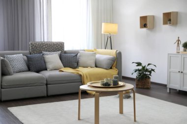 Pencerenin yanında rahat kanepesi olan şık bir oturma odası. İç tasarım