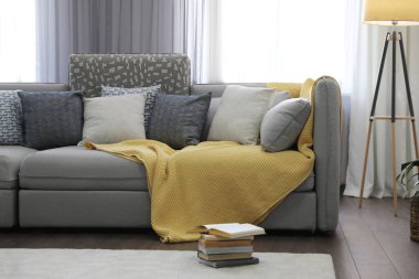 Pencerenin yanında rahat kanepesi olan şık bir oturma odası. İç tasarım