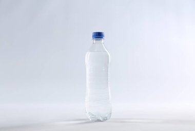 Beyaz üzerine izole edilmiş plastik bir şişe saf su.