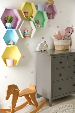 Odadaki ışık duvarındaki parlak renkli raflar. İç tasarım