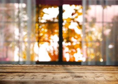 Güneşli sonbahar gününde pencerenin yanındaki boş ahşap masa