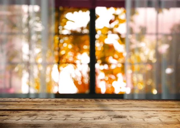 Güneşli sonbahar gününde pencerenin yanındaki boş ahşap masa