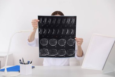 Ortopedist klinikteki masada röntgen filmini inceliyor.