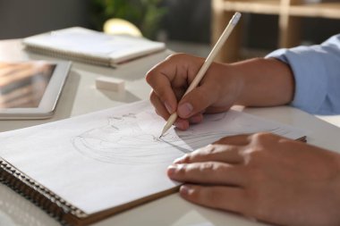 Masada kurşun kalemle resim çizen adam, yakın plan.