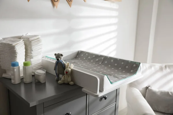 Chest of drawers with changing tray and pad in baby room. Interior design