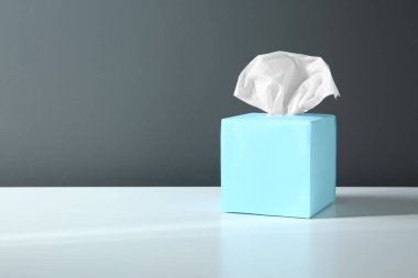 Beyaz masa üzerinde kağıt mendillerle dolu bir kutu. Metin için boşluk