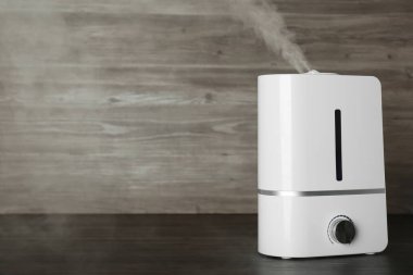 Ahşap masada modern hava nemlendirici. Metin için boşluk