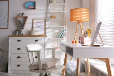 Pencerenin yanında rahat işyeri olan şık bir oda.