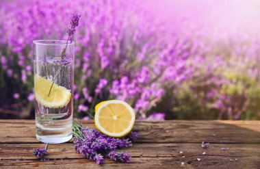 Limonata, limon dilimi ve ahşap masa üzerinde lavanta çiçekleri. Metin için boşluk
