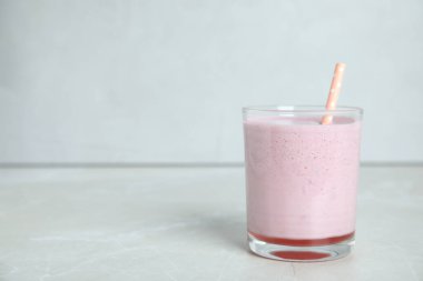 Açık gri masada pipetli lezzetli bir milkshake. Metin için boşluk