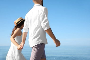 Deniz kenarında yürüyen mutlu genç bir çift. Balayı gezisi