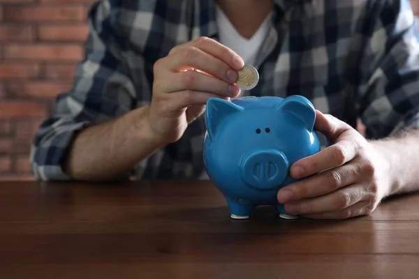 Man Sätter Mynt Spargris Bank Vid Träbord Närbild — Stockfoto