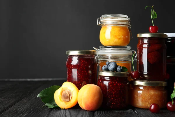 Frascos Com Diferentes Compotas Frutas Frescas Mesa Madeira Preta — Fotografia de Stock