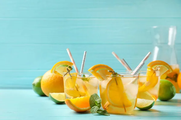 Köstliches Erfrischungsgetränk Mit Orangen Und Limettenscheiben Auf Hellblauem Holztisch — Stockfoto