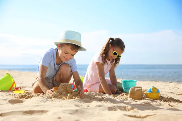 해변에서 플라스틱 장난감을 가지고 귀여운 어린이들 — 스톡 사진
