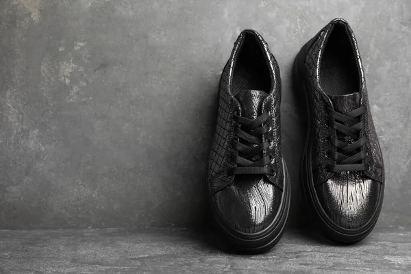 灰色石墙附近一双时髦的黑色鞋子 案文的篇幅 — 图库照片