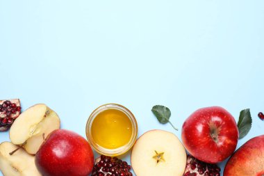 Bal, elmalar ve narlar açık mavi arka planda, düzlük ve metin için yer var. Rosh Hashanah tatili