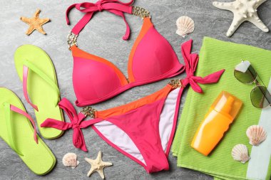 Gri taş zemin üzerinde plaj nesneleri ile düz bileşim yatıyordu