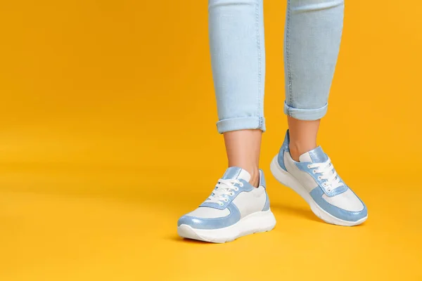 Mujer Con Elegantes Zapatillas Deporte Sobre Fondo Amarillo Primer Plano —  Fotos de Stock