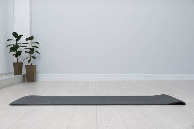Odanın zemininde siyah yoga minderi açık. Metin için boşluk