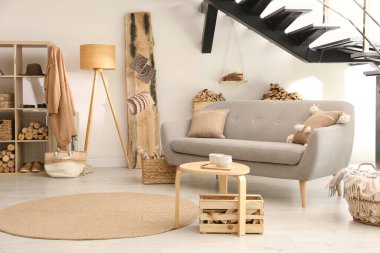 Dekoratif unsur olarak yakacak odunları olan şık bir oda.