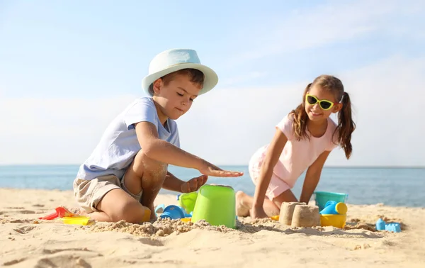 해변에서 플라스틱 장난감을 가지고 귀여운 어린이들 — 스톡 사진