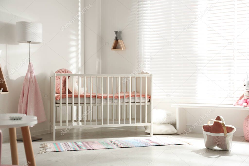 Cute baby room interior with crib and decor elements