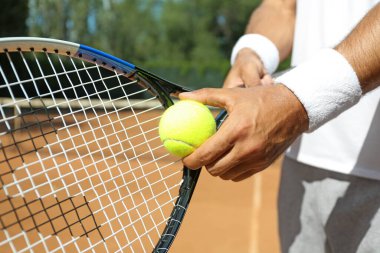 Sporcu sarayda tenis topu servis etmeye hazırlanıyor, yakın plan.
