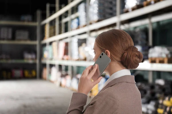 Wholesale and logistics concept. Manager talking on phone in warehouse