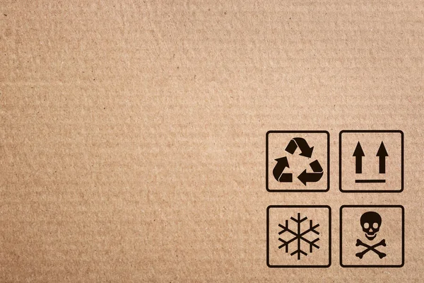 Cardboard box with packaging symbols as background, closeup