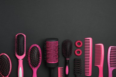 Modern saç tarakları ve siyah arka planda fırçalar ile düz kompozisyon