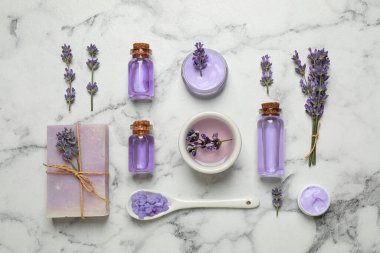 Kozmetik ürünleri ve lavanta çiçekleri beyaz mermer masa üzerinde, düz yatıyordu