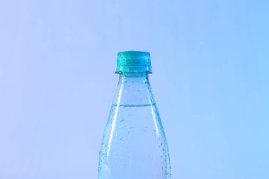 Arkaplanda plastik saf su şişesi, yakın plan.