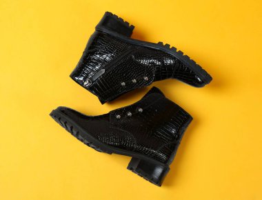 Sarı arka planda bir çift şık ayak bileği çizmesi, üst manzara.